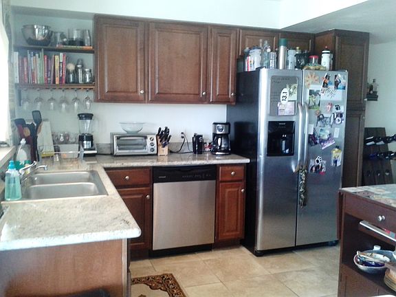 Kitchen has stainless steel appliances, custom cab's & grani