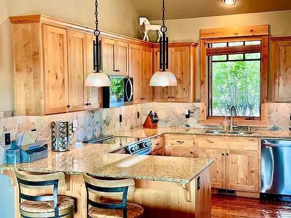 Fully stocked gourmet kitchen with two bar stools