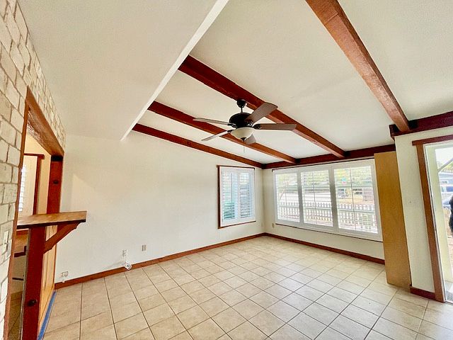 Beautiful living space featuring high ceilings, a ceiling fan and gorgeous wooden beams. Window shutters installed throughout the entire house.
