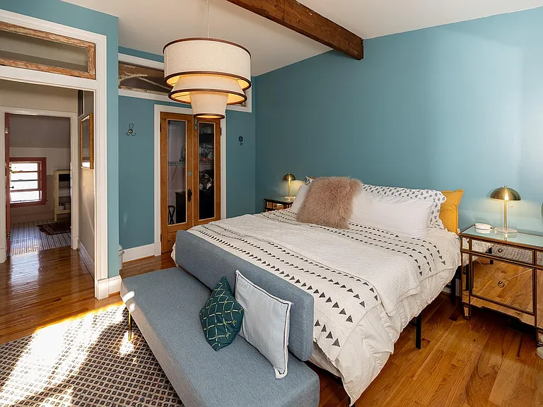 __ Welcome to our light-filled primary bedroom on the 3rd floor with black-out curtains for peaceful sleep. Notice our funky bathroom in the background, just off the bedroom.