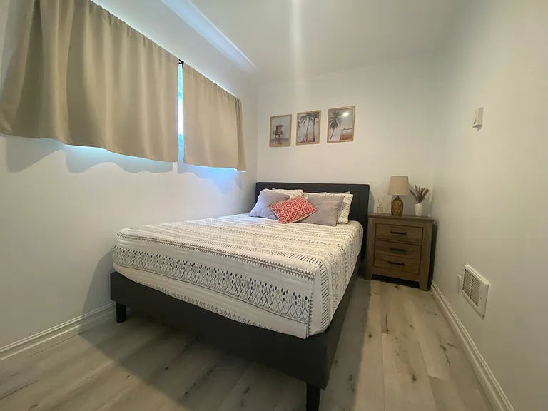 Bedroom with nightstand, closet, and storage racks in closet.