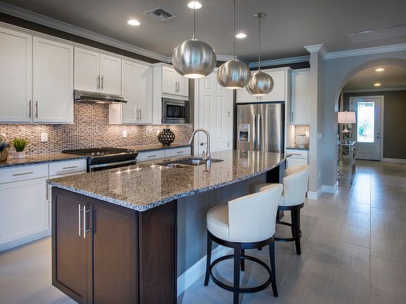 Model Representation Kitchen with stainless steel gas appliances, stylish backsplash tile, large