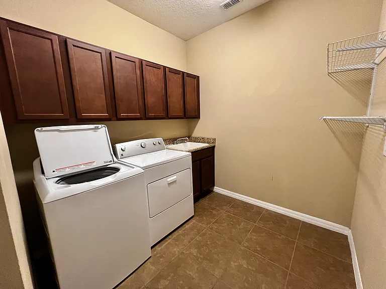 LAUNDRY ROOM ON 1ST FLOOR SPACIOUS AND OFFERS TONS OF STORAGE SPACE AND A SINK CONVENIENTLY LOCATED WITH STORAGE SHELVES TOO.
