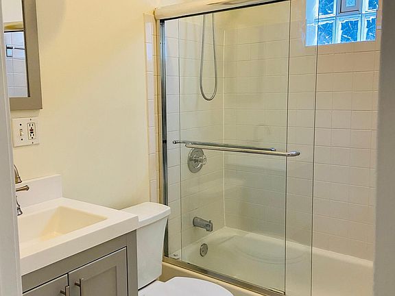 Clean bathroom with storage space inside vanity and extra cabinet behind door.