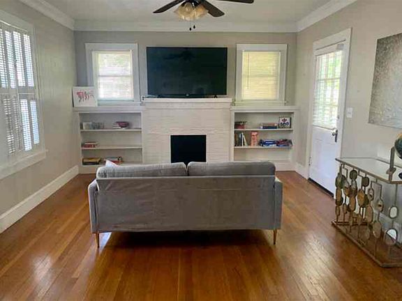 Large living room with lots of natural light. Decorative fireplace.