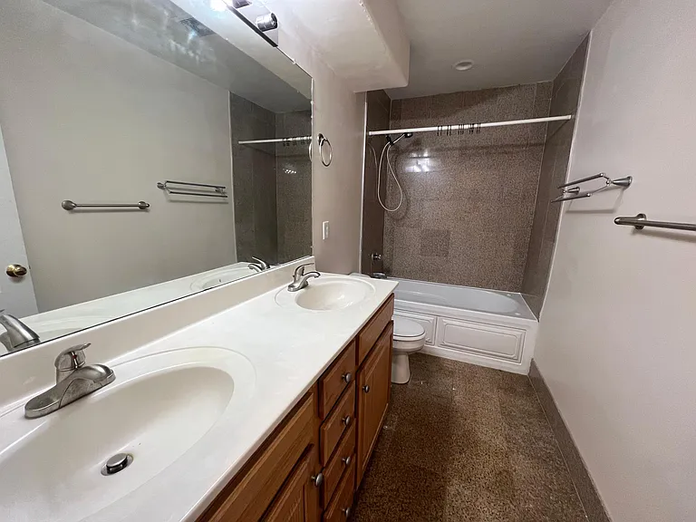 Bathroom off of the hallway with tub and double sinks.
