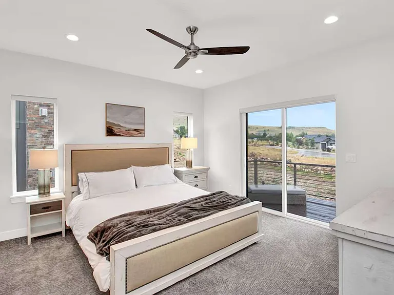 Master bedroom with king sized bed and french doors to deck