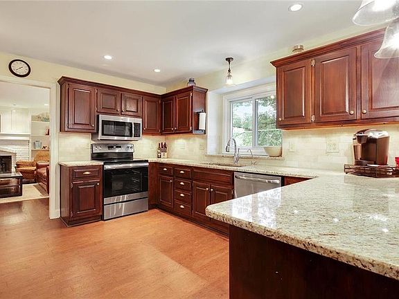 Updated Kitchen....cherry cabinets & Pantry, granite & backsplash, SS appliances, cork floors, recessed lighting. Kitchen opens to Breakfast/Eat-in area.