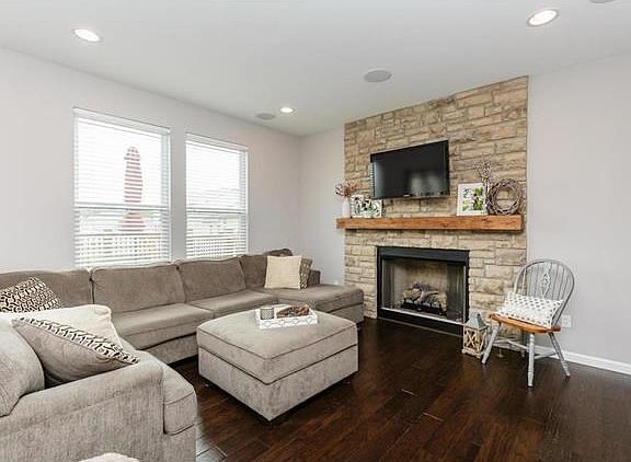 Hearth Room with Floor to Ceiling Stone Gas Fireplace and Wood Floors
