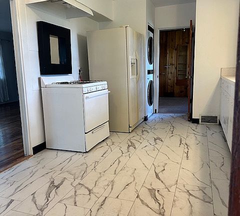 Entering the kitchen from the garage, living room to the left, cabinets and countertop to the right.