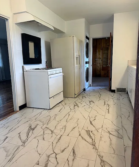 Entering the kitchen from the garage, living room to the left, cabinets and countertop to the right.