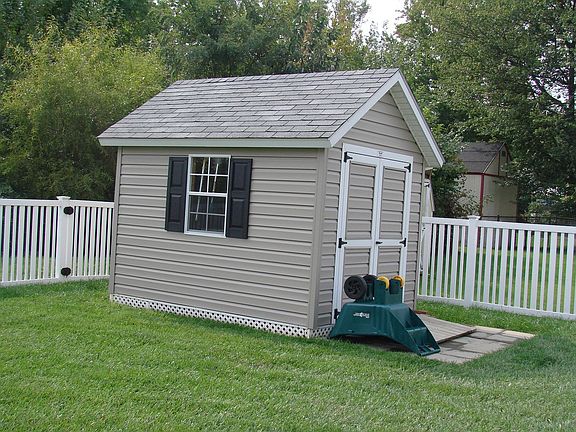 Shed  surrounded by new white vinyl fencing. backs to woods