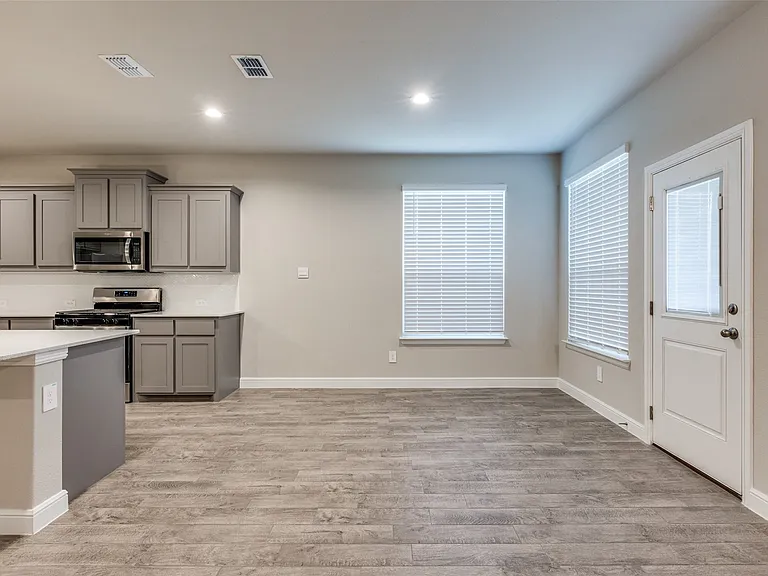 Kitchen with stainless steel appliances, gray cabinetry, and light hardwood / wood-style floors