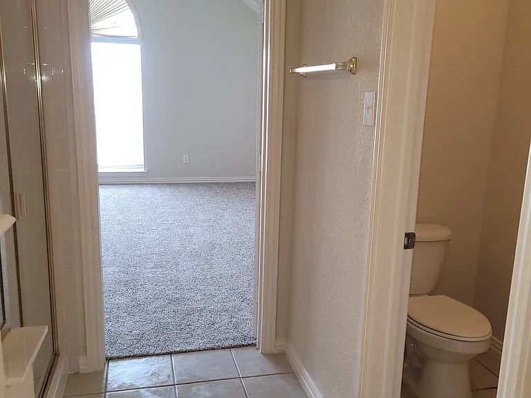 primary bath separate toilet with door across from shower stall