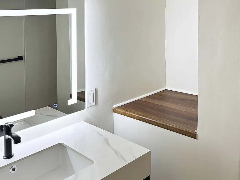 View of bath from entry, with storage shelf in background.
