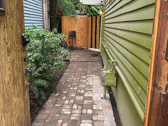 THROUGH GATE, PAVED WALKWAY AND PATIO TO HANG OUT. GARDEN WITH NATIVE PLANTS