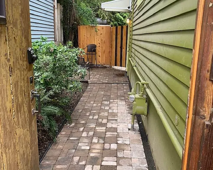 THROUGH GATE, PAVED WALKWAY AND PATIO TO HANG OUT. GARDEN WITH NATIVE PLANTS