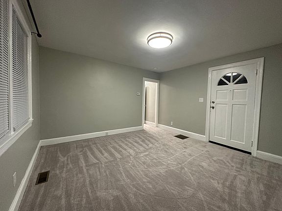 Living Room - new carpet and padding, fresh paint, new light fixtures, new blinds, curtain rods installed. Hallway with additional storage.