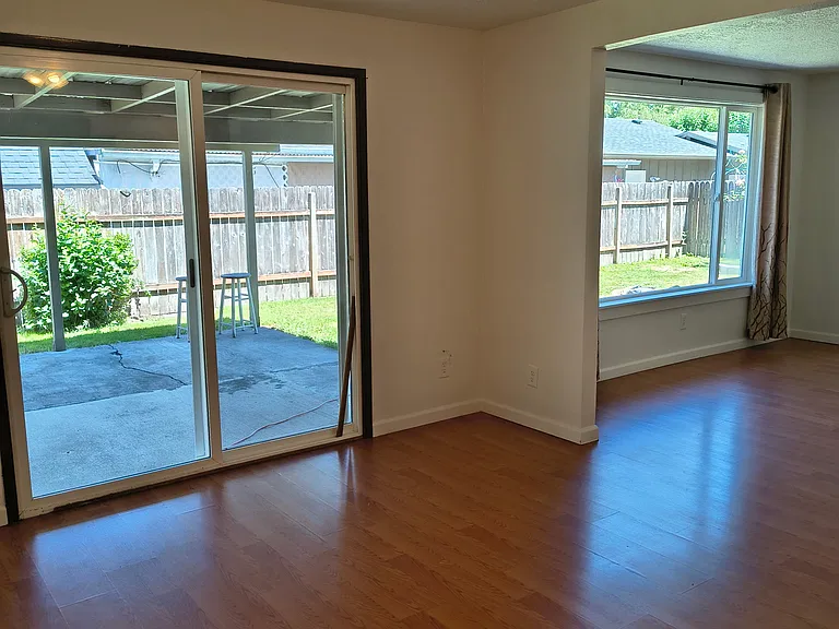 Looking from family room into living room and onto covered back patio and back yard