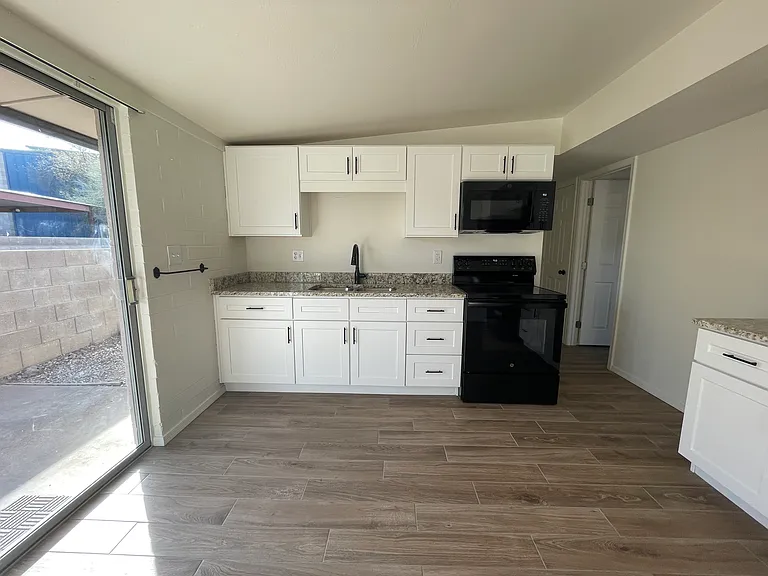 Kitchen w/ granite countertops, new cabinets, and appliances.