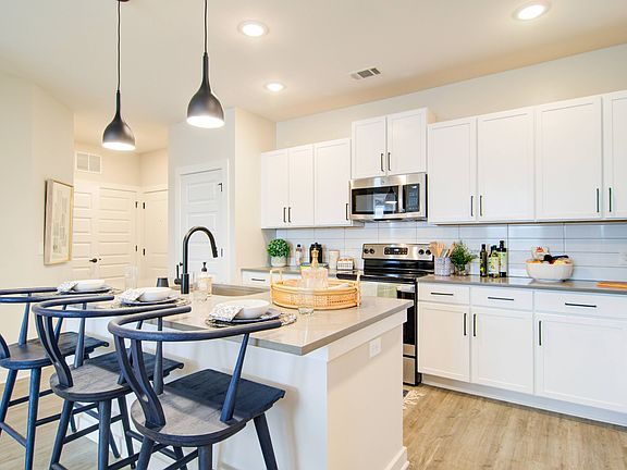 Designer grey or white shaker-style cabinetry with high-end tile backsplash