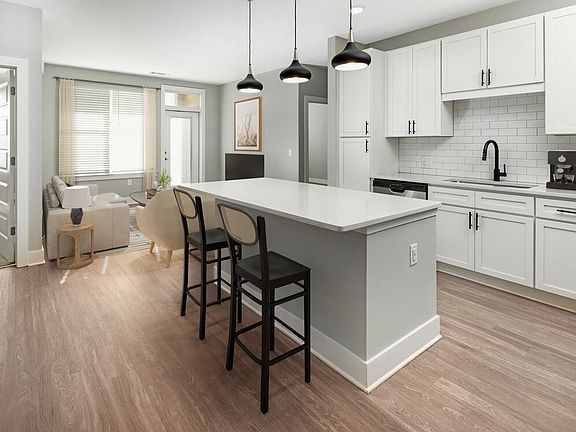 Modern kitchen with white cabinetry, white quartz countertop, stainless steel appliances, and hard surface flooring