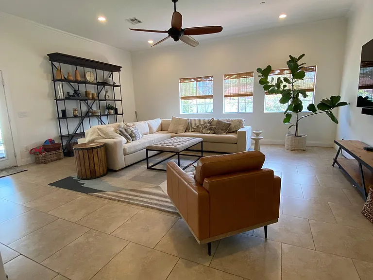 Living room that opens up to the kitchen with 10' ceilings, dog door, and door to backyard.