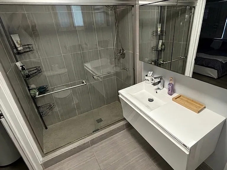 Master Bathroom
Fully renovated master en-suite with large walk-in glass shower, floor-to-ceiling tile, floating vanity, and oversized mirror
