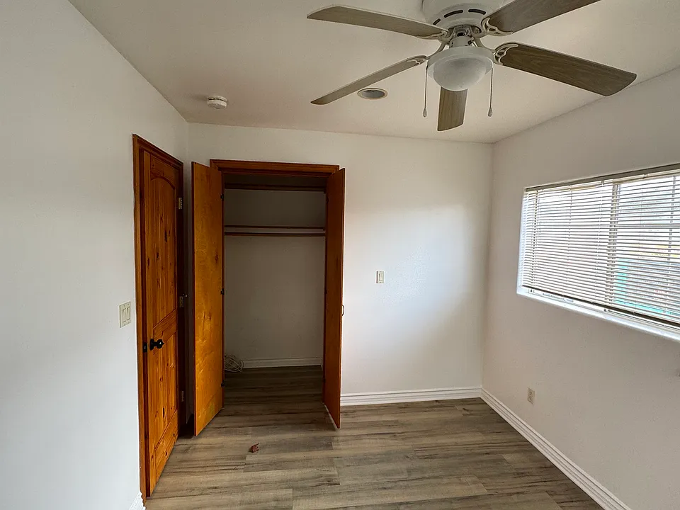 Bedroom with ceiling fan showing the closet as well.