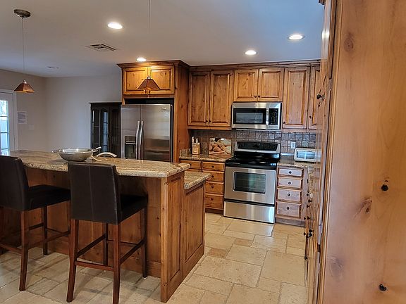 Kitchen with center island and barstools.