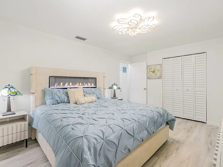 Master Bedroom with King size bed with visual fireplace, 2 nightstands, dresser and 50" Smart Samsung TV