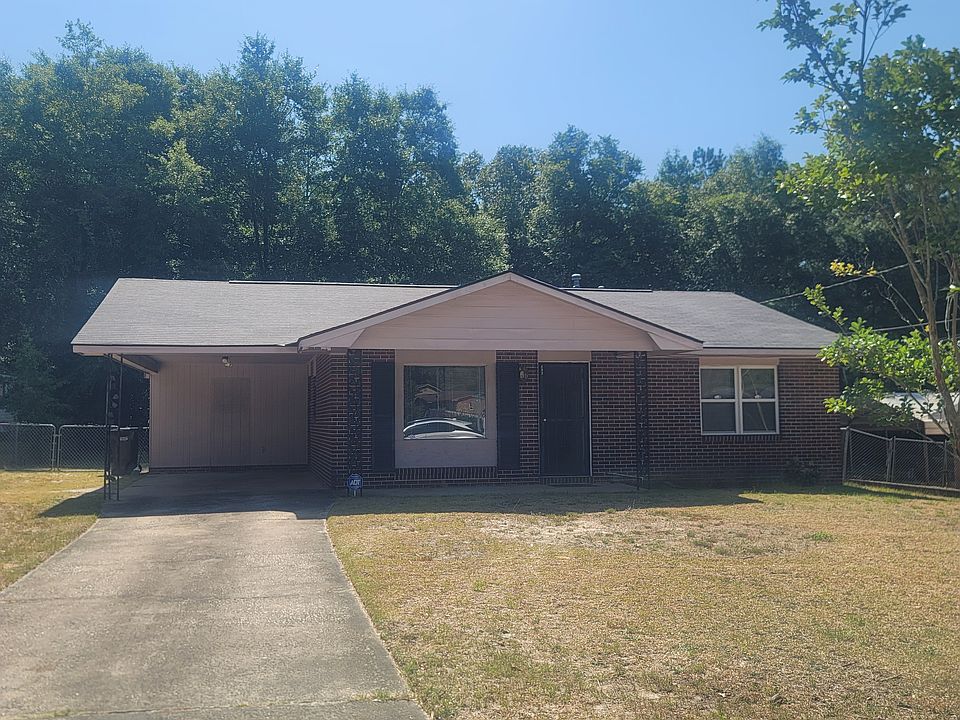 Full front view of house with driveway and carport