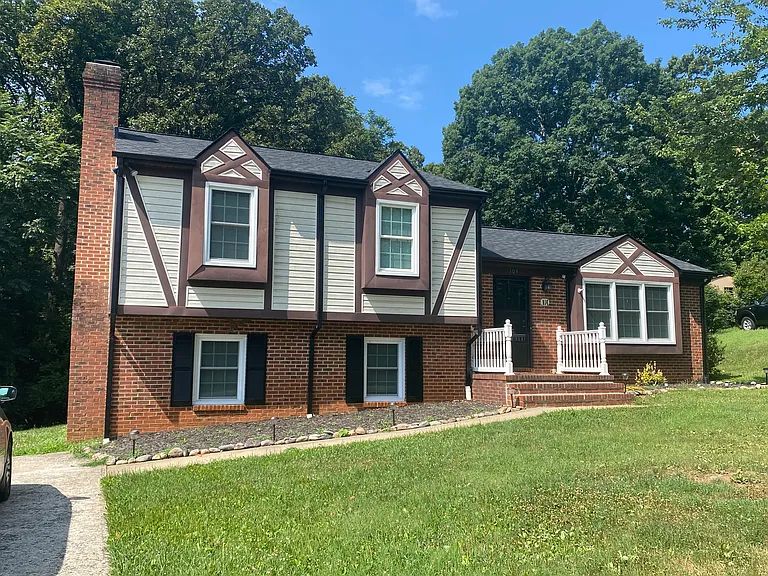 Tutor style split level house with brick and vinyl siding and a new roof