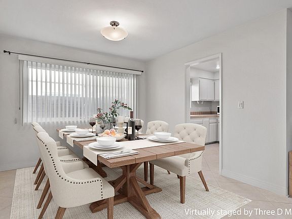 Dining room leads to the kitchen and opens to the living room with sliding glass doors to the enclosed patio.