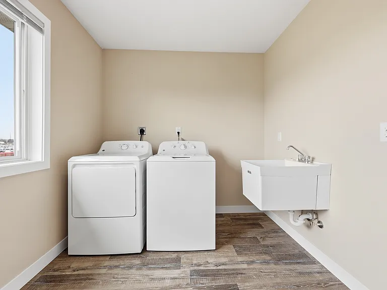 Upper level laundry with deep sink and window.