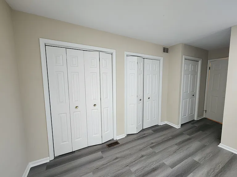 Full wall of closets in primary bedroom, in addition to walk-in closet