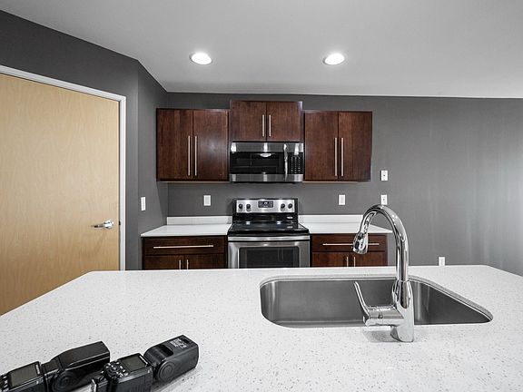 Modern kitchen with sleek quartz countertops, stainless steel appliances, and rich wooden cabinetry, perfect for gourmet cooking. Modern kitchen with sleek quartz countertops, stainless steel appliances, and rich wooden cabinetry, perfect for gourmet cook