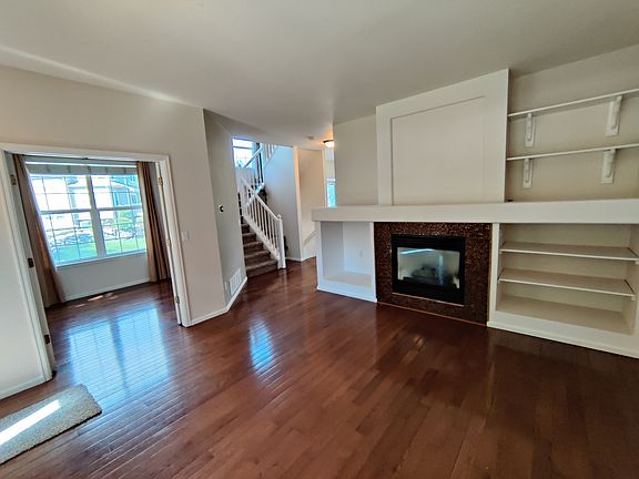 Living room with view of home office and stairway