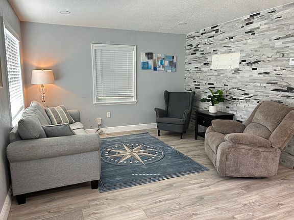 Living room is spacious with contemporary stone tile accent wall