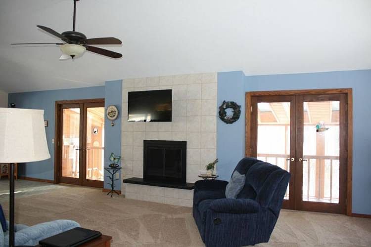 The living room features vaulted ceilings, new carpet, fresh paint, and wood burning fireplace with gas available if preferred. The sunroom and screened porch are easily accessed from both levels.