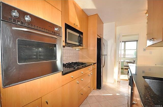 New custom eat-in-kitchen with Granite counters, custom cabinets and stainless steel appliances including a dishwasher, microwave, refrigerator, wall oven and stove top.