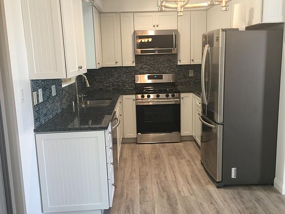 Gourmet kitchen with top of the line smart refrigerator/freezer, gas range/oven, built in microwave and dishwasher plus large sink all in chrome. Soft close white cabinets and blue granite from Brazil and real glass backsplash. Its a dream!