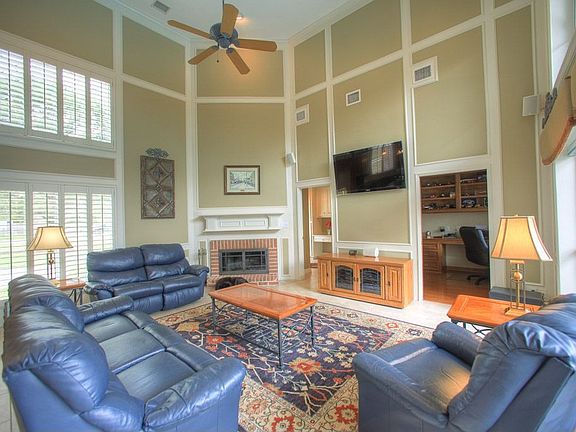 The living room features plantation shutters, beautiful trim work and an invit