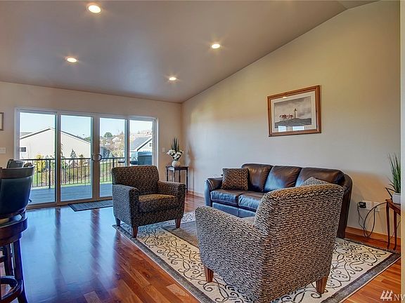 An open floor plan with vaulted ceilings and gorgeous cherry hardwood floors. Large sliding doors lead to deck and views.