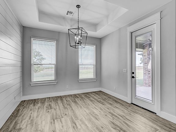 Dining area with a chandelier and door to the patio.