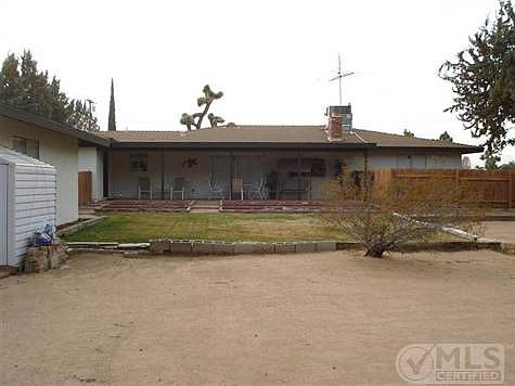 Rear view of covered patio and raised bed garden area