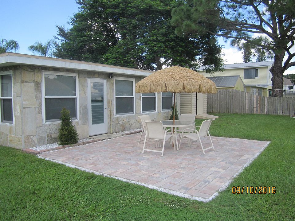 back by water, patio and table, grill included