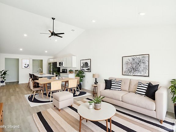 Great room amply sized for formal dining table, and casual dining at the 9 foot island, as well as lounging area that overlooks 8' sliding glass door and covered porch. Luxury Vinyl Plank flooring throughout