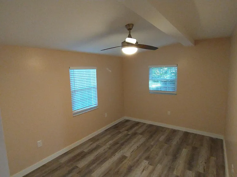 Second bedroom with architectural beam and ceiling fan