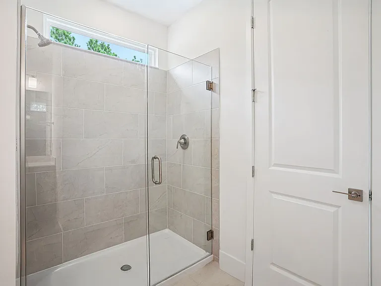 Master bathroom with seamless shower glass, transom, and privacy water closet